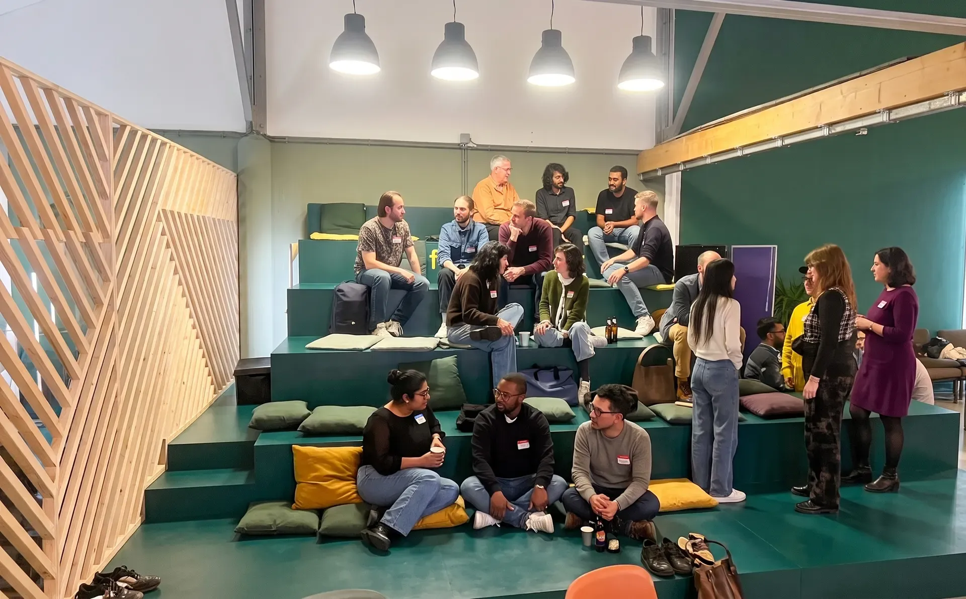 Members of the community sitting and talking together on tiered seating at a meet-up.